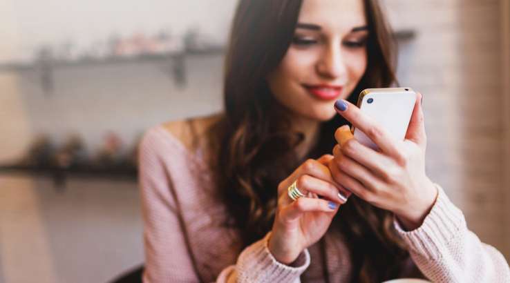 Muchacha guapa viendo un perfil en su smartphone